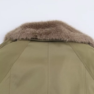 Detail of olive green jacket featuring a thick premium brown faux fur collar and stitching