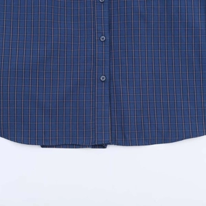 Detail view of the deep blue plaid shirt hem with fine stitching and resin buttons