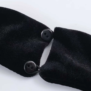 Close-up of black velvet dress back closure with two glossy buttons and elastic loops
