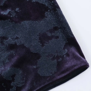 Detail of velvet dress fabric with purple marble texture and professional hem stitching