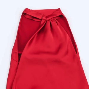 Détail du col en satin rouge avec un nœud élégant et une texture plissée raffinée