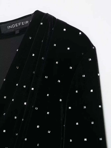 Close-up of black velvet midi dress showing V-neckline and shiny silver square rhinestones