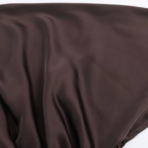 Détail du tissu satiné café noir haut de gamme avec drapé souple et texture de soie