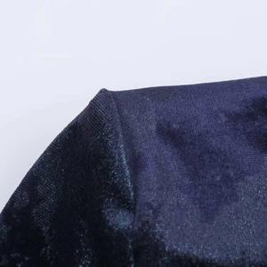 Macro shot of dark blue velvet fabric showing fine texture and premium shoulder stitching