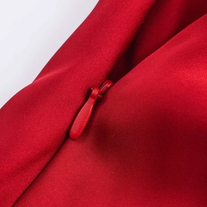 Gros plan sur la fermeture éclair invisible d'une robe en satin rouge élégante