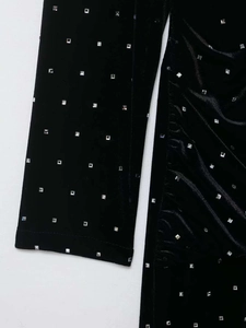 Close-up of black velvet midi skirt featuring silver square rhinestones and ruched detailing