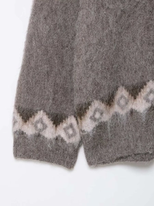 Dettaglio maglione in mohair grigio scuro con texture soffice e motivo geometrico beige
