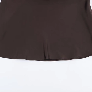 Gros plan détaillé de l'ourlet de la robe en satin marron foncé avec couture fine