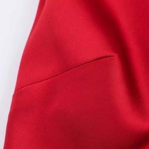 Détail du tissu en satin rouge avec des coutures soignées sur une robe d'été chic