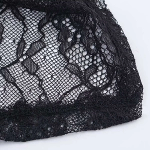 Close-up detail of elegant black floral lace fabric with honeycomb mesh on velvet dress