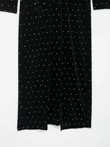 Detail of black velvet midi skirt featuring silver beaded dots and a side slit hemline