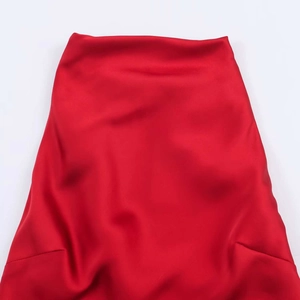 Détails des plis en satin rouge montrant une texture brillante et un drapé élégant