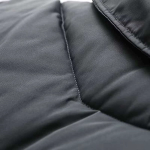 Detail of dark grey quilted fabric and precise stitching on the winter puffer jacket