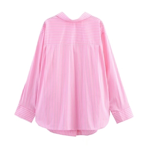 Detail view of pink and white striped oversized shirt with classic collar and curved hem