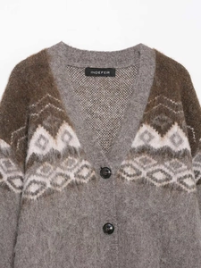 Dettaglio del cardigan in maglia con scollo a V, trama spessa e motivo jacquard retro