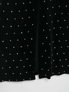 Detail view of black velvet fabric featuring rows of square silver beaded embellishments