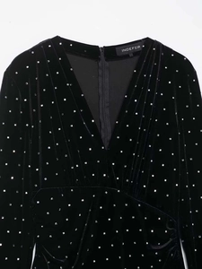 Close-up of black velvet dress featuring V-neckline and shiny silver square sequin beads