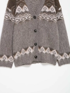 Dettaglio dell'abbigliamento del cardigan grigio in maglia con motivi jacquard marroni