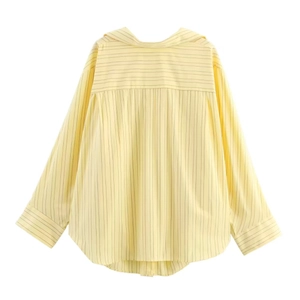 Detail view of the pale yellow striped shirt featuring back seam and curved hemline