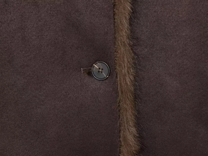 Close-up of stylish faux fur collar and polished four-hole button on the winter jacket