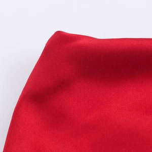 Vue détaillée de la texture du satin de soie rouge foncé et des plis à la taille