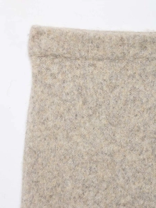 Detail of high-waist knitted skirt showing thick wool texture and neat edge stitching