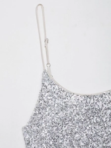 Détail de la robe à paillettes argentées avec bretelles réglables et texture métallique