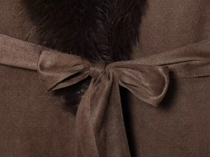 Detail of coffee brown wool coat featuring a soft fur collar and tied bow waist belt