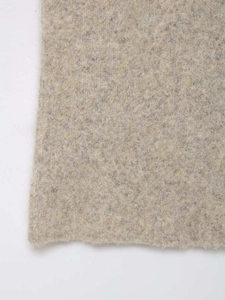 Detailed macro texture of beige knitted fabric showing soft high-quality fiber weave