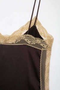 Close-up of deep brown satin fabric with delicate champagne floral lace trim details