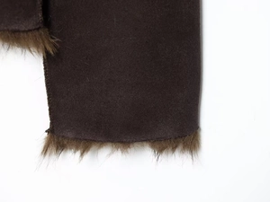 Detail of dark brown faux suede fabric and brown faux fur trim on the sleeve cuff