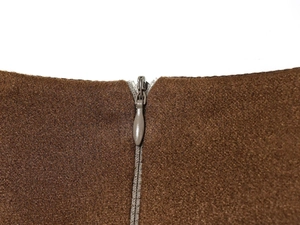 Detailaufnahme des verdeckten Reißverschlusses am braunen Strickkleid im Vintage-Stil