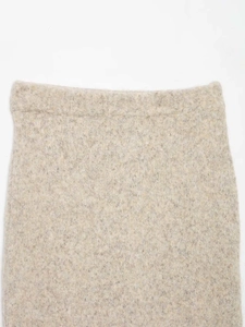 Detail of oat-beige knit high waist skirt showing soft brushed wool texture and stitching