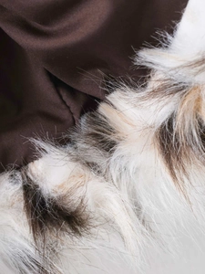 Close-up of deep brown fabric and soft multi-colored faux fur collar on the long coat