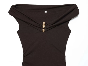 Detailed view of black off-shoulder dress with golden buttons and ruched fabric details