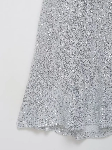 Gros plan des paillettes argentées scintillantes sur l'ourlet d'une robe brillante