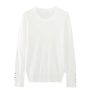 Detail view of white knit sweater cuff featuring elegant gold metal button accents
