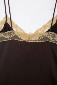 Close-up of elegant dark brown satin top featuring delicate beige lace trim on the neckline