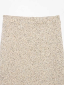 Close-up of the elastic waistband on a textured oatmeal knitted skirt for women