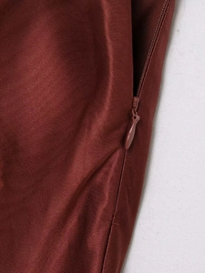 Détail d'une jupe en satin bordeaux à taille haute avec fermeture éclair invisible