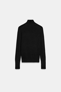 Detail of premium black turtleneck knit sweater showing fine texture and sleek silhouette