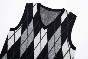 Detail of V-neck knitted argyle vest dress with classic black and white diamond pattern