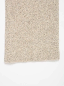 Detail shot of beige wool blend knitted fabric showing soft texture and high-quality stitching