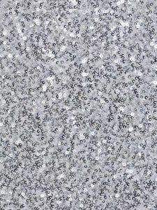 Vue macro d'un tissu à paillettes argentées avec des disques métalliques réfléchissants
