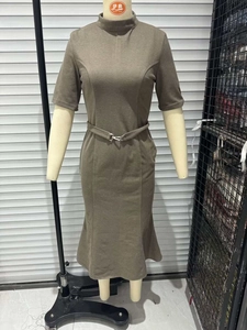 Detail of slim-fit brown midi dress featuring a mock neck, short sleeves, and metal buckle belt