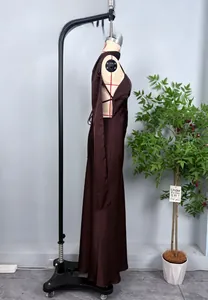 Détail d'une élégante robe longue en satin marron avec licou et découpes latérales
