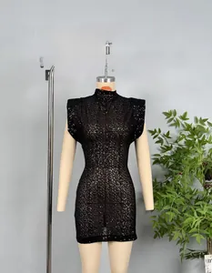 Close-up of black sequined dress featuring padded shoulders and shimmering fabric detail
