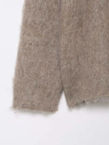 Vue détaillée de l'ourlet du pull en maille mohair marron clair et sa texture duveteuse