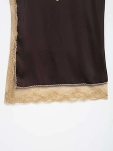 Close-up of dark brown satin fabric with delicate champagne lace trim detailing