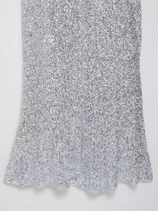 Détail de la texture des paillettes argentées et de l'ourlet de la robe de soirée
